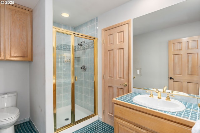 bathroom featuring toilet, a shower stall, tile patterned flooring, baseboards, and vanity