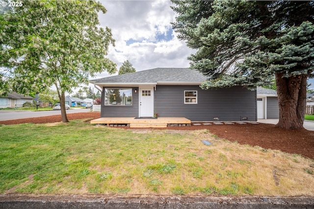 view of front of home featuring a front lawn, roof with shingles, a deck, and a garage