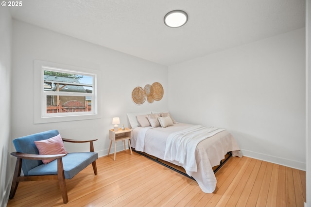 bedroom featuring baseboards and hardwood / wood-style flooring