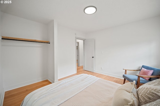 bedroom with baseboards and light wood finished floors
