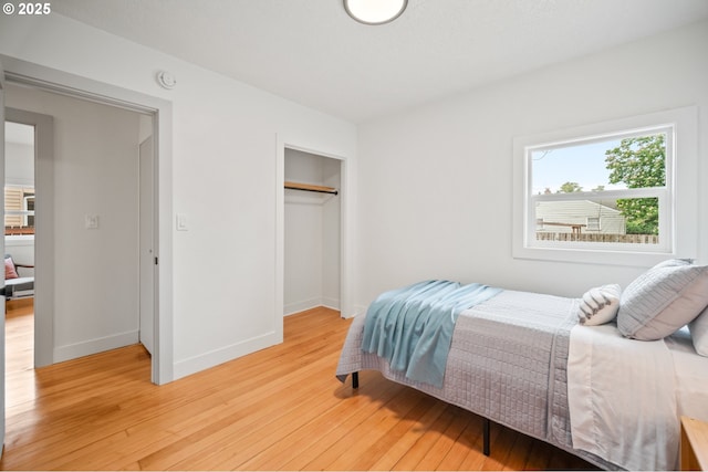 bedroom featuring light wood-style floors, a closet, and baseboards