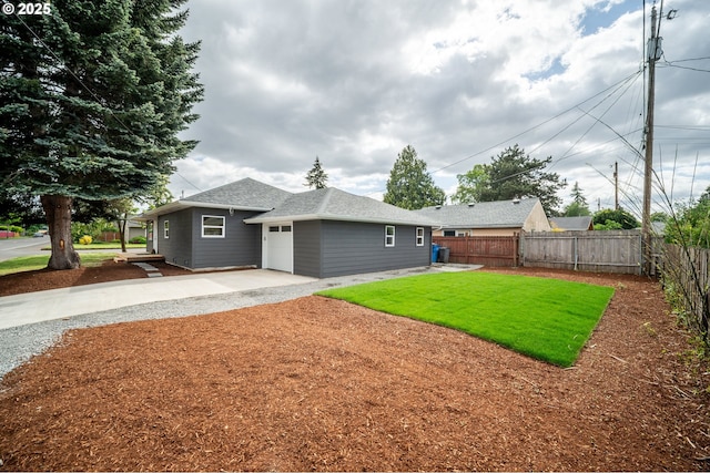 back of property featuring concrete driveway, an attached garage, roof with shingles, and a patio