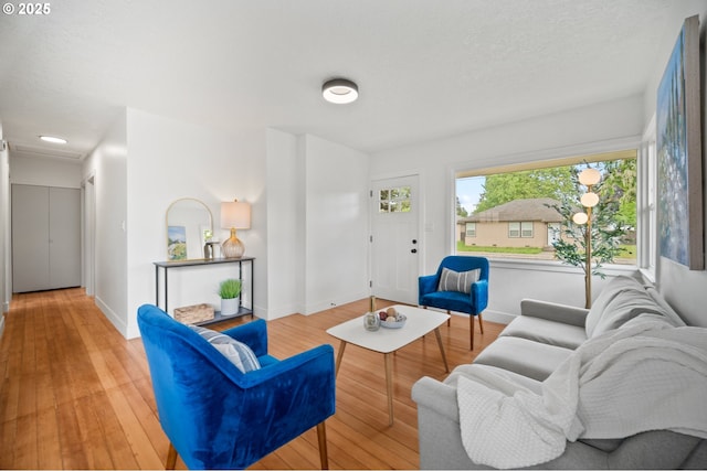 living area with light wood-type flooring and baseboards