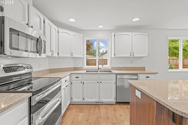 16508 NE 29th St, Vancouver, WA 98682 - kitchen with appliances with stainless steel finishes, white cabinets, light wood-type flooring, light stone counters, and recessed lighting