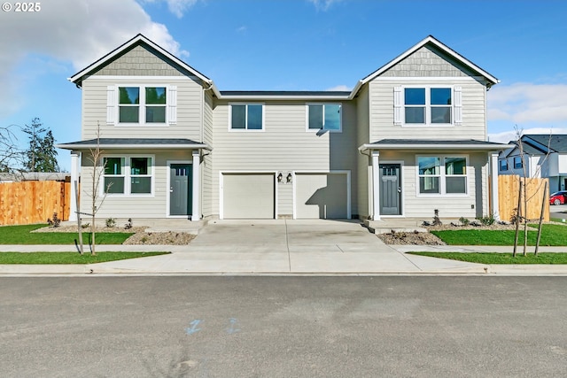 view of front facade with a garage, fence, and driveway