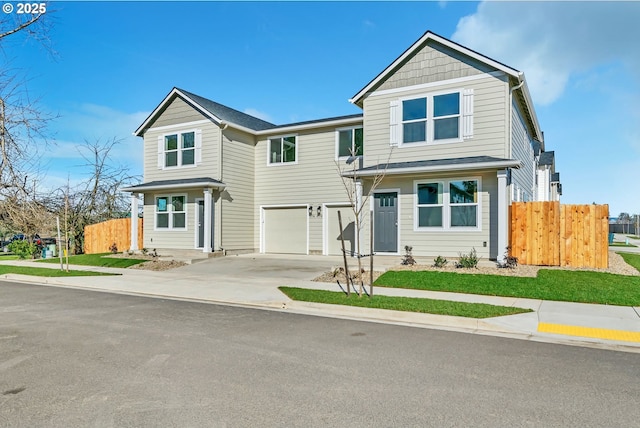 view of front facade featuring driveway, a garage, and fence