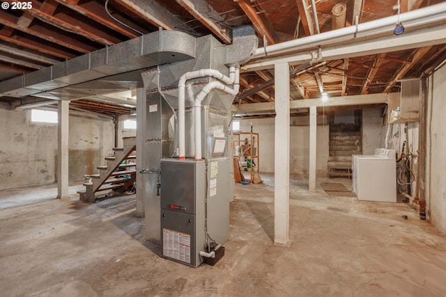 basement featuring heating unit, stairway, and washer / clothes dryer