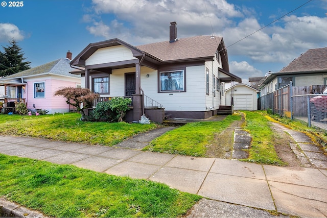 bungalow-style home featuring an outbuilding, fence, driveway, a chimney, and a detached garage