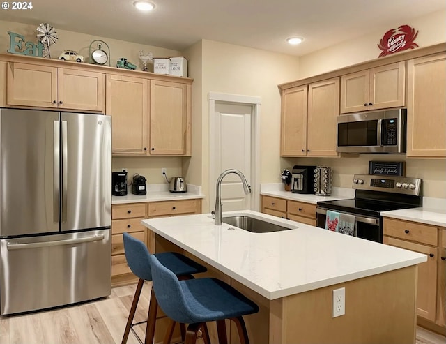 kitchen featuring light brown cabinetry, sink, a center island with sink, and appliances with stainless steel finishes