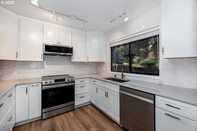 kitchen featuring appliances with stainless steel finishes, white cabinetry, and sink