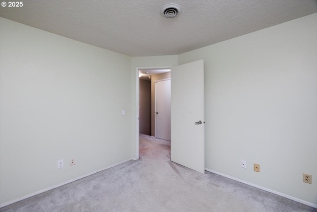 carpeted empty room with a textured ceiling