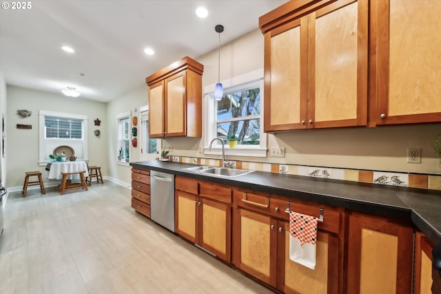 kitchen with recessed lighting, a sink, pendant lighting, stainless steel dishwasher, and dark countertops