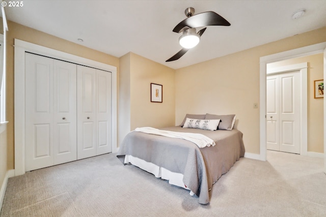 bedroom featuring a closet, baseboards, light colored carpet, and a ceiling fan