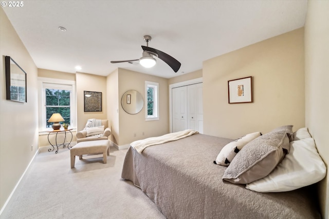 carpeted bedroom featuring a closet, baseboards, and ceiling fan