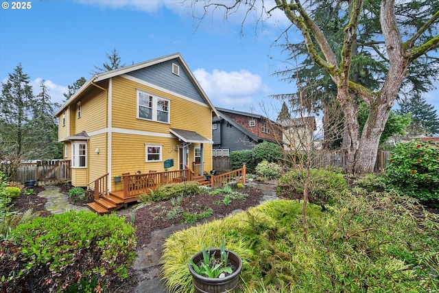 rear view of property featuring a deck and a fenced backyard