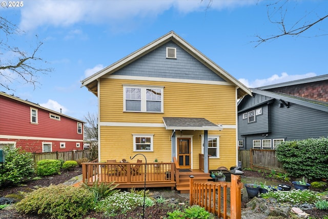 back of property with a deck and a fenced backyard