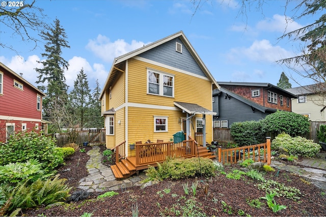 rear view of house with a deck and fence