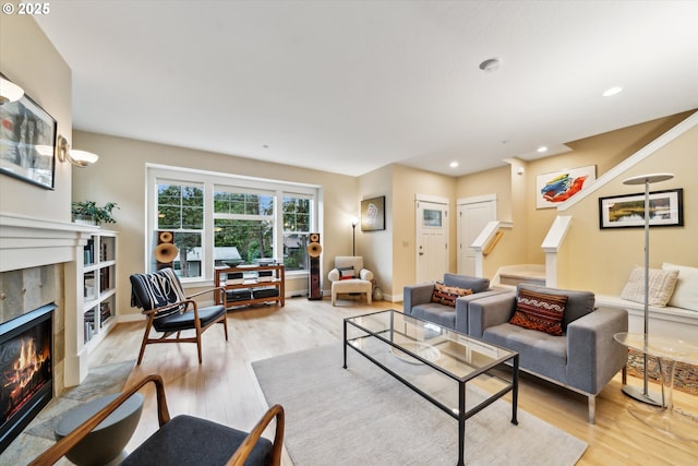 living room with stairway, baseboards, light wood-style flooring, recessed lighting, and a fireplace