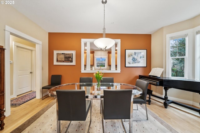 dining area with baseboards and light wood-type flooring