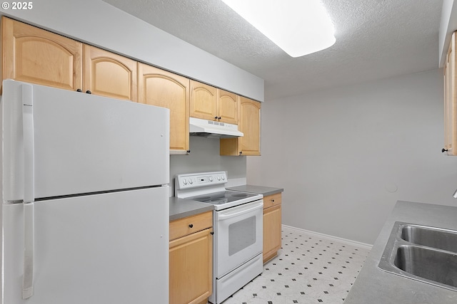 kitchen with white appliances, light brown cabinetry, sink, and a textured ceiling