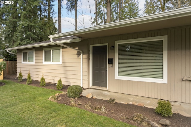 doorway to property with a lawn