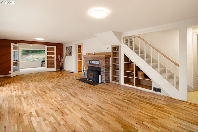 54 W 31st Ave, Eugene, OR 97405 - unfurnished living room with wood finished floors, a wood stove, and stairway