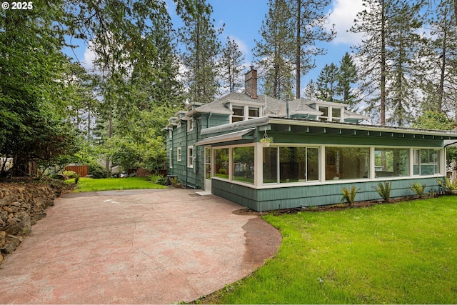 54 W 31st Ave, Eugene, OR 97405 - rear view of property featuring a sunroom, a lawn, a chimney, and a patio area