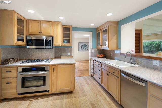 54 W 31st Ave, Eugene, OR 97405 - kitchen with stainless steel appliances, light countertops, light wood-style flooring, glass insert cabinets, and recessed lighting