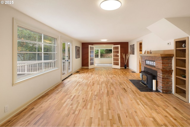 54 W 31st Ave, Eugene, OR 97405 - unfurnished living room featuring wood finished floors, a wood stove, and healthy amount of natural light