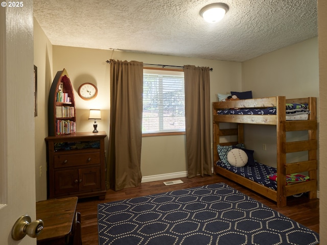 2605 NE 189th St, Ridgefield, WA 98642 - bedroom featuring visible vents, dark wood finished floors, a textured ceiling, and baseboards