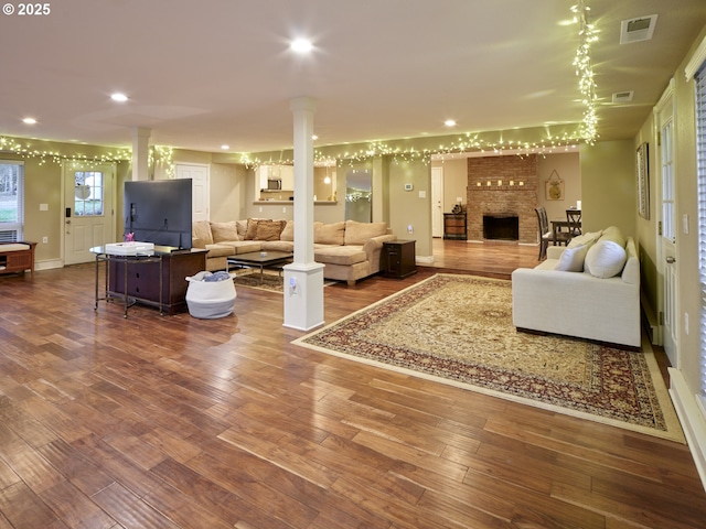 2605 NE 189th St, Ridgefield, WA 98642 - living room with a fireplace, decorative columns, recessed lighting, visible vents, and hardwood / wood-style flooring