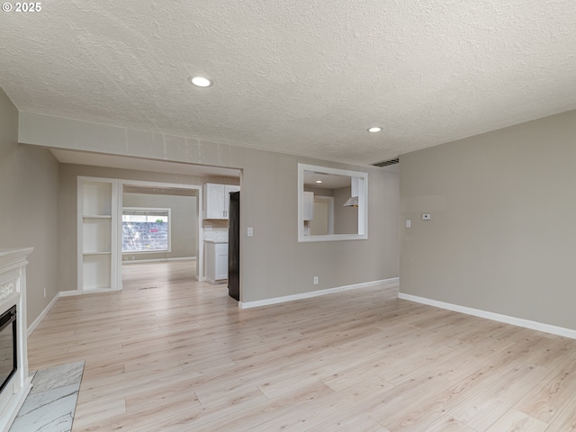 11421 SE Pardee St, Portland, OR 97266 - unfurnished living room with a textured ceiling, a premium fireplace, light wood-style floors, baseboards, and recessed lighting