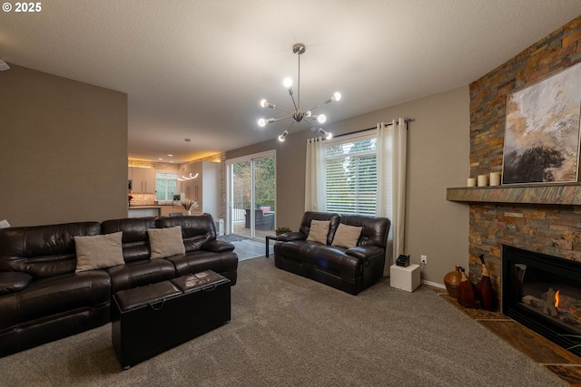 living room featuring carpet floors, a notable chandelier, and a stone fireplace