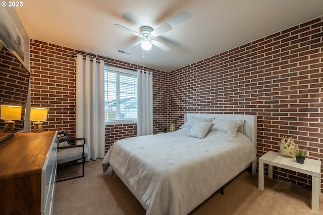 bedroom with ceiling fan, brick wall, and light carpet