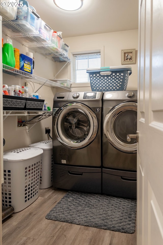 clothes washing area with light wood-type flooring and washing machine and dryer