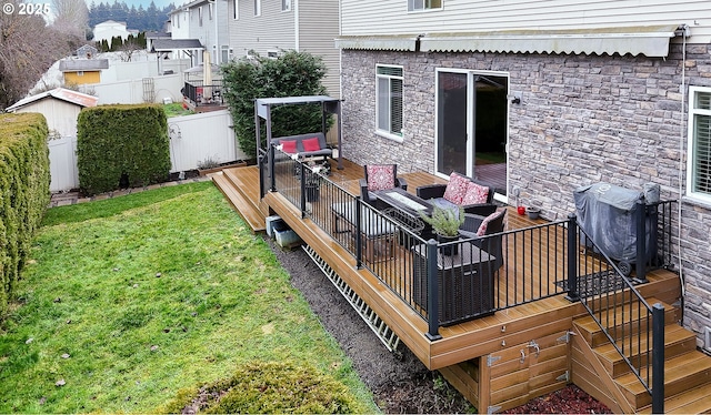 wooden terrace featuring grilling area, outdoor lounge area, and a yard