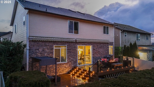 back house at dusk with a deck