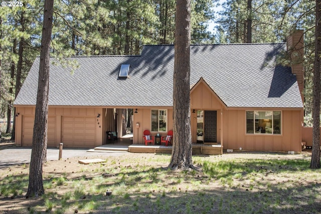 14023 Hawks Beard Unit Gm164, Black Butte Ranch, OR 97759 - back of property featuring board and batten siding, an attached garage, a chimney, roof with shingles, and driveway