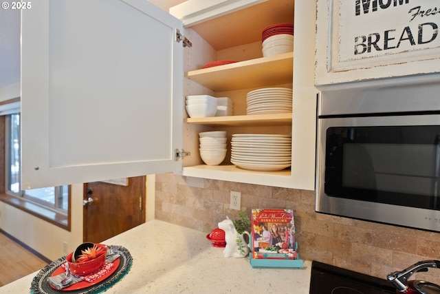 14023 Hawks Beard Unit Gm164, Black Butte Ranch, OR 97759 - kitchen view of stainless steel microwave, open shelves, tasteful backsplash, and white cabinetry