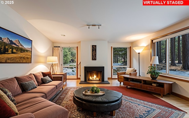 14023 Hawks Beard Unit Gm164, Black Butte Ranch, OR 97759 - living area featuring wood finished floors, healthy amount of natural light, a lit fireplace, and baseboards