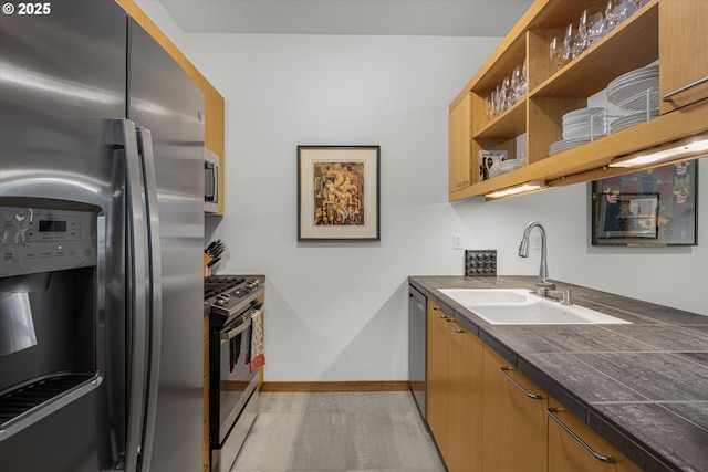 725 NW 10th Ave Unit 303, Portland, OR 97209 - kitchen with baseboards, open shelves, a sink, appliances with stainless steel finishes, and dark countertops