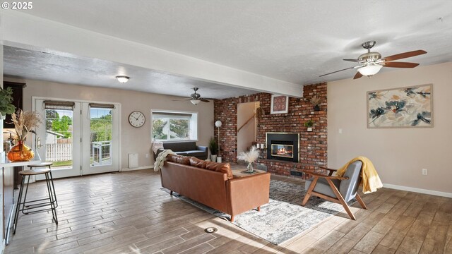 1060 SW 7th St, Hermiston, OR 97838 - living area featuring ceiling fan, wood finished floors, baseboards, a brick fireplace, and a textured ceiling