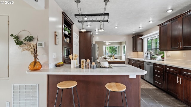 1060 SW 7th St, Hermiston, OR 97838 - kitchen featuring appliances with stainless steel finishes, a sink, a kitchen bar, and a peninsula