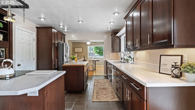 1060 SW 7th St, Hermiston, OR 97838 - kitchen featuring a sink, a kitchen island, appliances with stainless steel finishes, ceiling fan, and dark brown cabinets