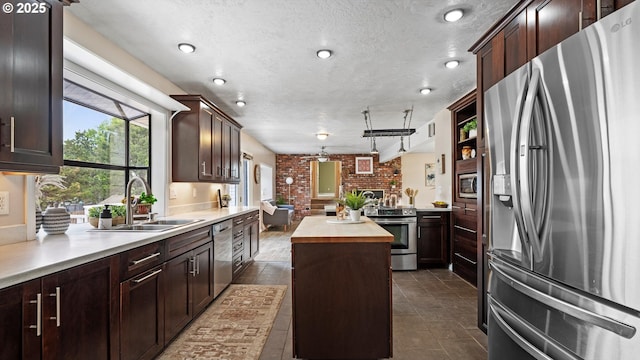 1060 SW 7th St, Hermiston, OR 97838 - kitchen featuring stainless steel appliances, a sink, brick wall, butcher block countertops, and a center island