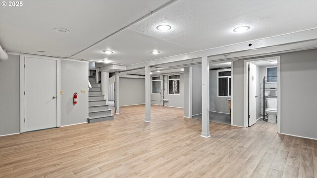 1060 SW 7th St, Hermiston, OR 97838 - finished below grade area with light wood-style floors, stairs, and a textured ceiling
