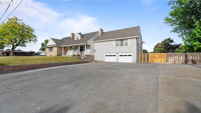 1060 SW 7th St, Hermiston, OR 97838 - view of front of property featuring asphalt driveway, a chimney, a garage, roof with shingles, and a porch