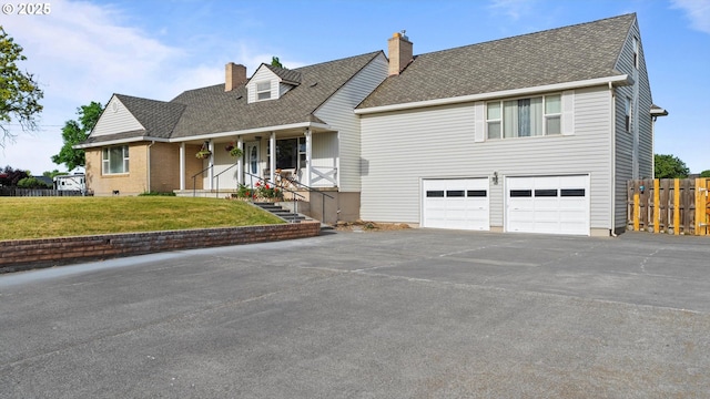 1060 SW 7th St, Hermiston, OR 97838 - cape cod-style house featuring a chimney, asphalt driveway, an attached garage, covered porch, and a shingled roof