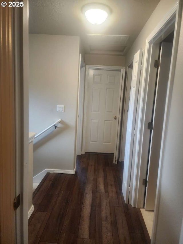 hallway featuring baseboards, hardwood / wood-style floors, and an upstairs landing