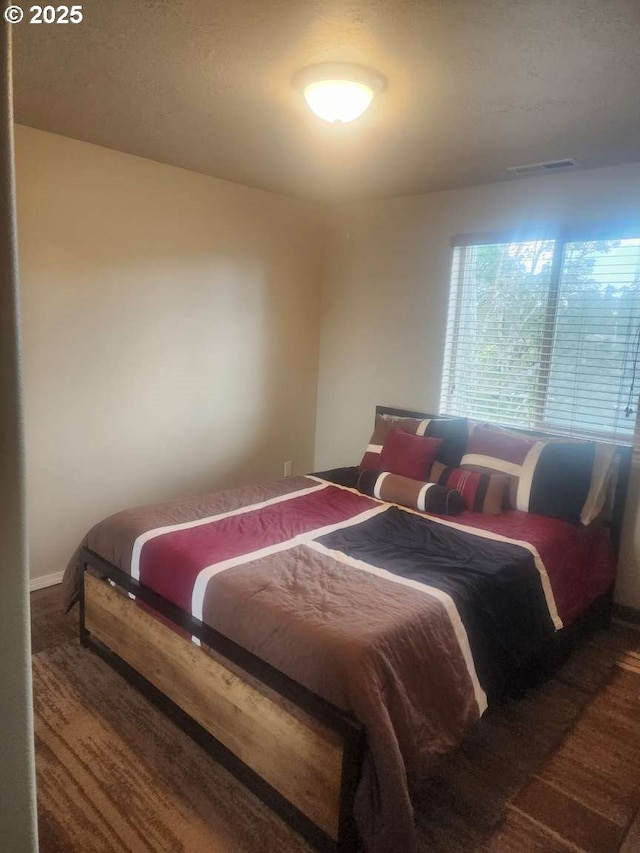 bedroom featuring baseboards and visible vents